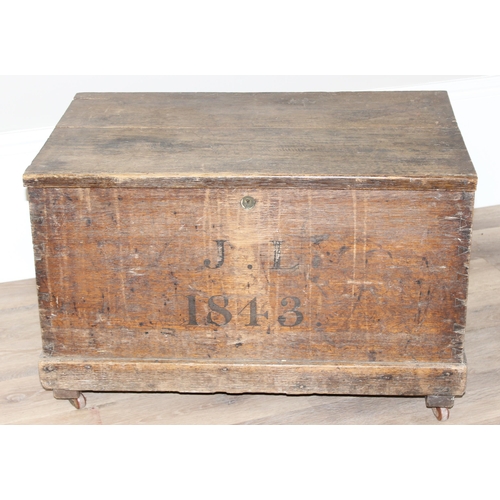 43 - A 19th century wooden trunk with painted decoration, dated 1843 with initials JL, on later wheels, a... 