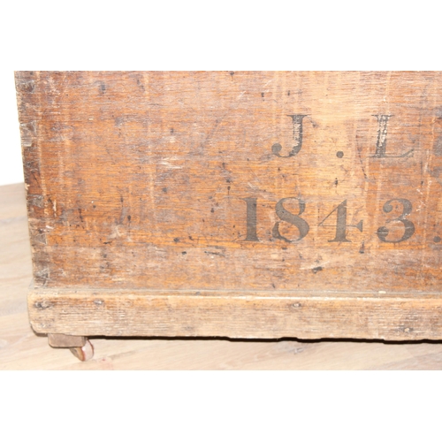 43 - A 19th century wooden trunk with painted decoration, dated 1843 with initials JL, on later wheels, a... 