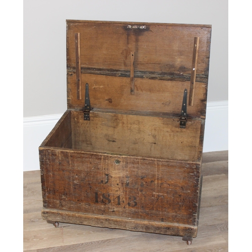 43 - A 19th century wooden trunk with painted decoration, dated 1843 with initials JL, on later wheels, a... 