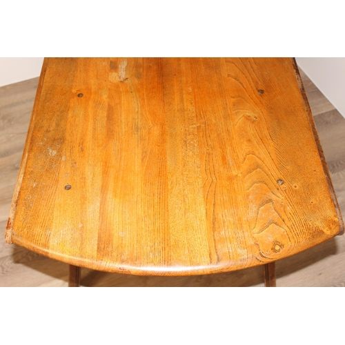 30 - A retro Ercol drop leaf dining table, oval topped, approx 60cm wide (124cm extended) x 113cm deep x ... 