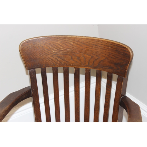 93 - An early 20th century oak captain's chair or desk chair with slat back and leather seat, approx 90cm... 