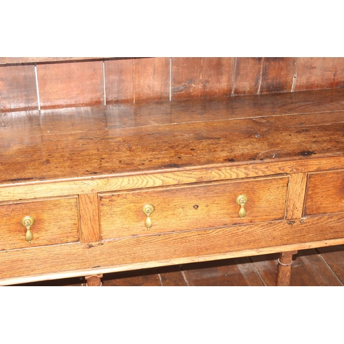 86 - A Georgian oak dresser, the base with 3 drawers with brass drop handles and the top with 3 shelves, ... 