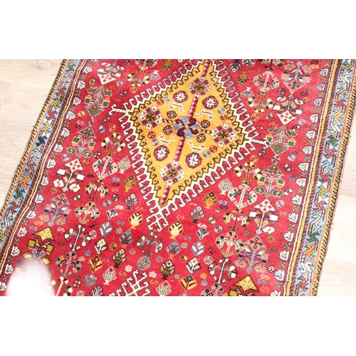 210 - A highly decorative hand made runner rug of red ground, likely Turkish, approx 210cm x 76cm