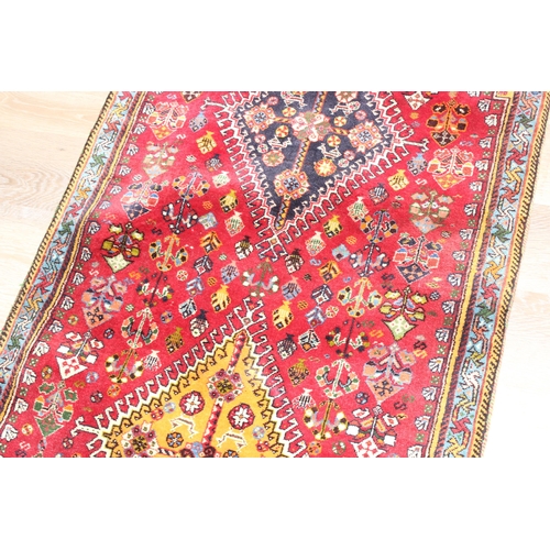 210 - A highly decorative hand made runner rug of red ground, likely Turkish, approx 210cm x 76cm