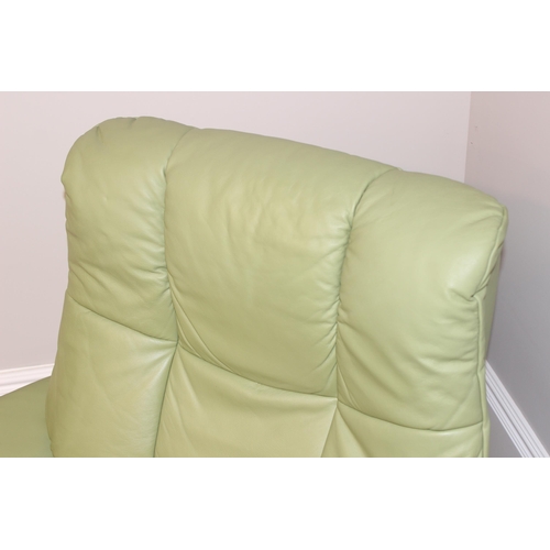 39 - A light green leather Ekornes Stressless armchair and a similar footstool, approx 104cm wide x 81cm ... 