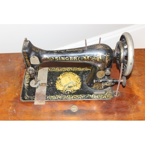 25 - Vintage Singer sewing machine on table with cast iron base, approx 89cm wide x 41cm deep x 105cm tal... 