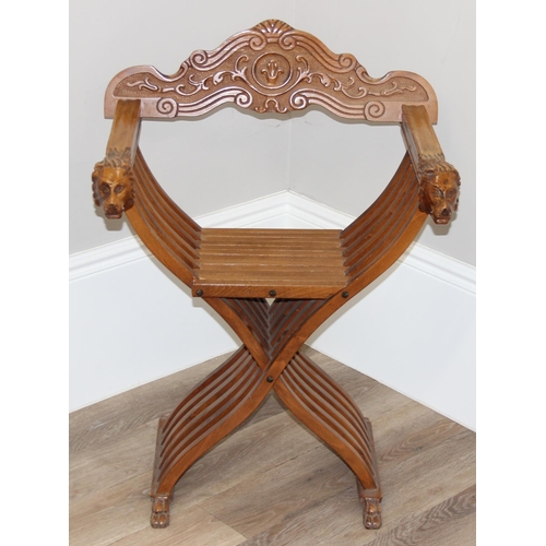 110 - Heavily carved light oak X-frame Savonarola collapsible chair with lion head arms and carved back, a... 