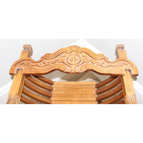 110 - Heavily carved light oak X-frame Savonarola collapsible chair with lion head arms and carved back, a... 