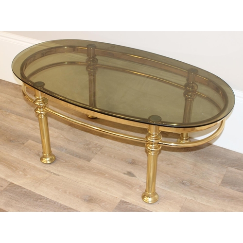 132 - A retro gilt metal and smoked glass topped coffee table, approx 111cm wide x 60cm deep x 45cm tall