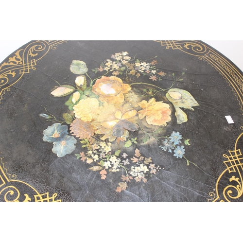 143 - An antique black painted tilt topped table with gilt painted border and central painted flowers with... 