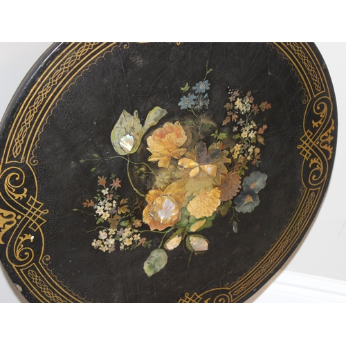 143 - An antique black painted tilt topped table with gilt painted border and central painted flowers with... 