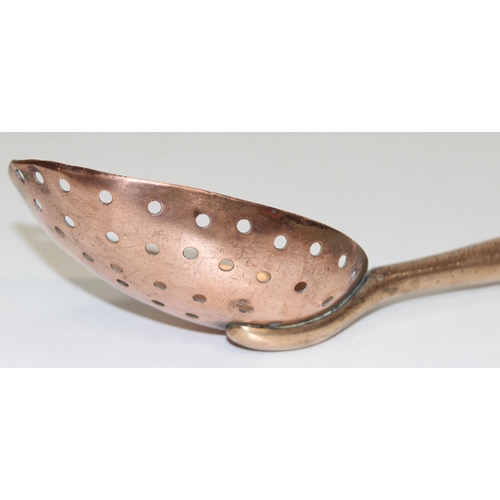 1800 - An antique heavy-gauge long turned-handled copper and brass straining spoon with half-pierced bowl, ... 