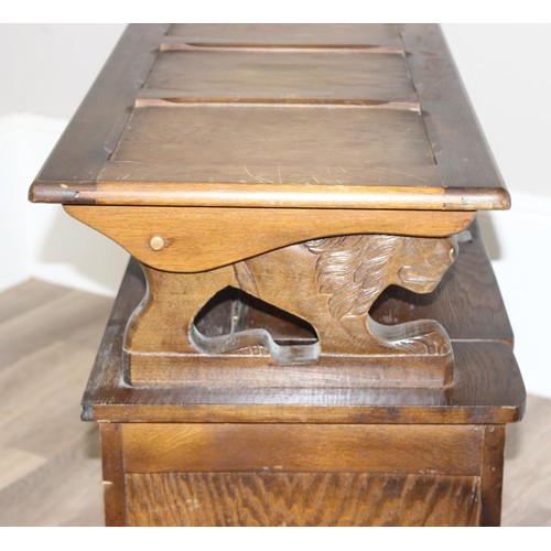 127 - A vintage antique style carved oak Monk's bench or storage box with lion supports, approx 96cm wide ... 