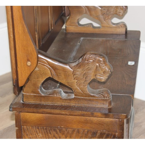 127 - A vintage antique style carved oak Monk's bench or storage box with lion supports, approx 96cm wide ... 