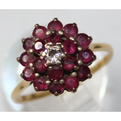 1104 - An 18ct gold diamond and ruby floral cluster ring, a small central diamond surrounded by 18 small ru... 