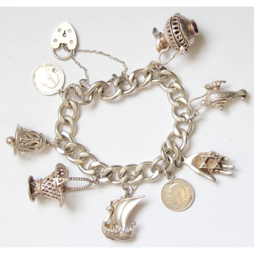 1138 - A vintage silver charm bracelet with charms to inc Viking Longboat, Aladdin's Lamp etc, approx 69.22... 