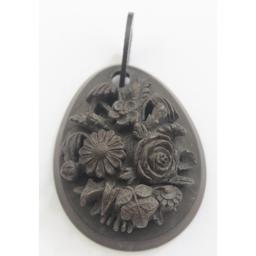 1142 - An unusual deep carved Victorian mourning jewellery pendant, carved in relief with flowers, believed... 