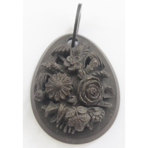 1142 - An unusual deep carved Victorian mourning jewellery pendant, carved in relief with flowers, believed... 