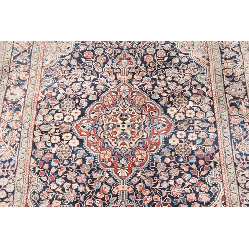 212 - A vintage Heriz style rug of blue ground with decorative motifs, approx 155cm x 114cm