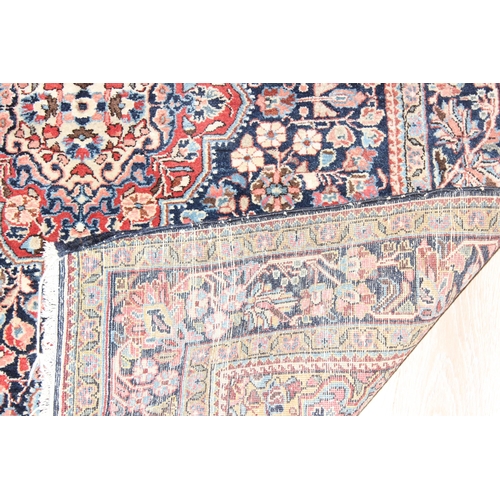 212 - A vintage Heriz style rug of blue ground with decorative motifs, approx 155cm x 114cm