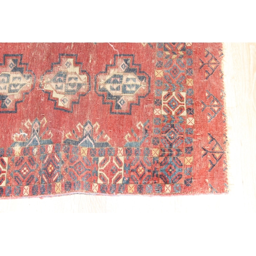 213 - A vintage Turkoman style rug of red ground with various gul decoration, approx 130cm x 88cm