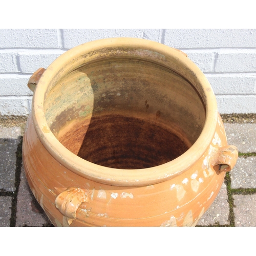 389 - A Terracotta drip glazed garden pot with 4 small ring handles, approx 50cm tall