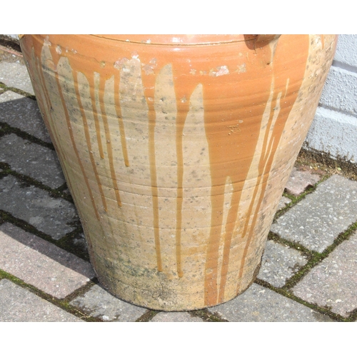 389 - A Terracotta drip glazed garden pot with 4 small ring handles, approx 50cm tall