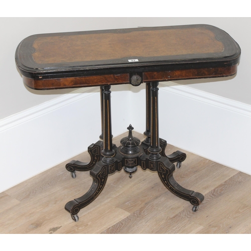 92 - A Victorian burr walnut and ebonised card or games table standing on pillar supports with blue baize... 