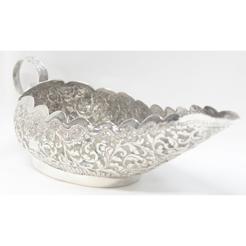 1071 - A highly decorative Anglo-Indian or Burmese silver sauce boat with embossed decoration, unmarked but... 