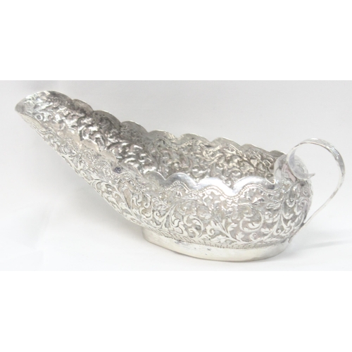 1071 - A highly decorative Anglo-Indian or Burmese silver sauce boat with embossed decoration, unmarked but... 