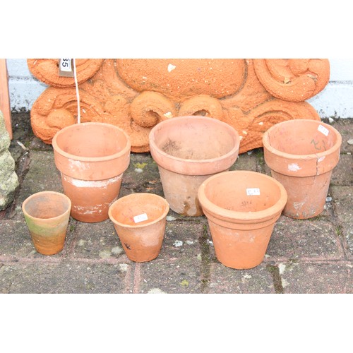 385 - Qty of terracotta and stone garden items to include a terracotta wall finial approx 50cm W x 36cm H