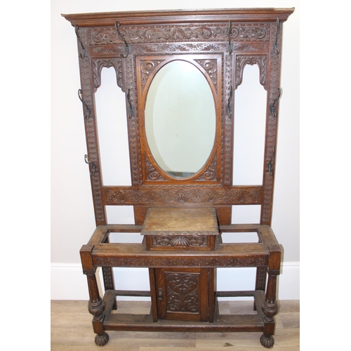 5 - Antique oak hall stand with heavily carved decoration and wrought iron coat hooks, with maker's mark... 