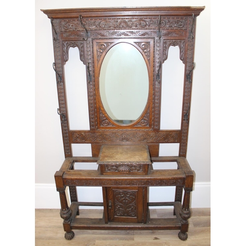 5 - Antique oak hall stand with heavily carved decoration and wrought iron coat hooks, with maker's mark... 