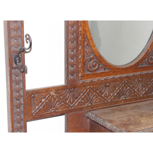 5 - Antique oak hall stand with heavily carved decoration and wrought iron coat hooks, with maker's mark... 