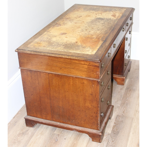 106 - An antique mahogany pedestal desk with 9 drawers and distressed leather top, approx 130cm wide x 69c... 