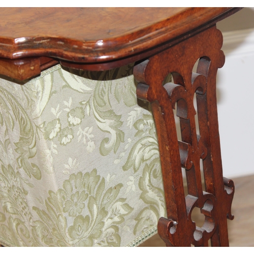 46 - A Victorian walnut sewing table with fabric bag and decorative supports, with contents, approx 59cm ... 