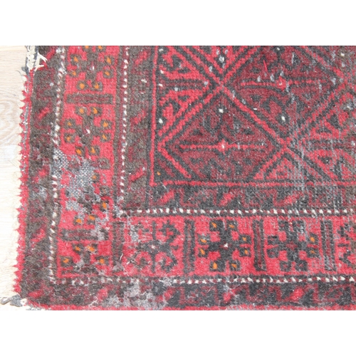 202 - A vintage red ground rug, possibly Afghan, approx 140cm x 90cm