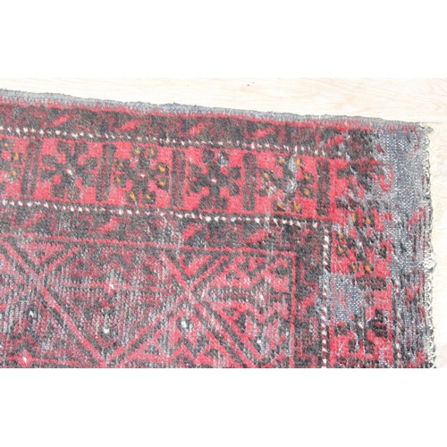 202 - A vintage red ground rug, possibly Afghan, approx 140cm x 90cm