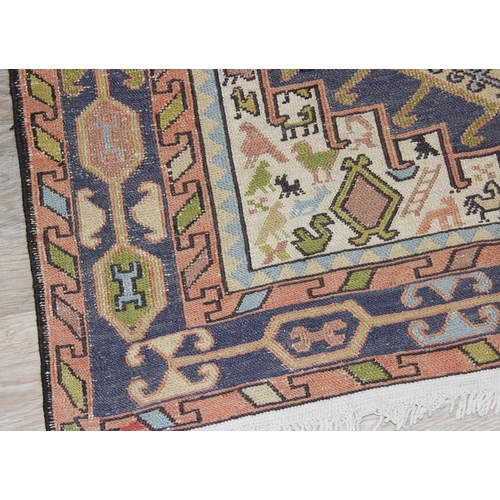 203 - A vintage Persian rug of cream and blue ground decorated with animal motifs and geometric designs, a... 