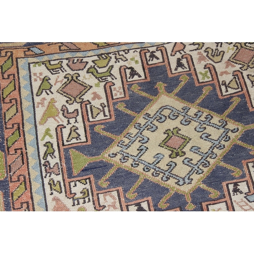 203 - A vintage Persian rug of cream and blue ground decorated with animal motifs and geometric designs, a... 