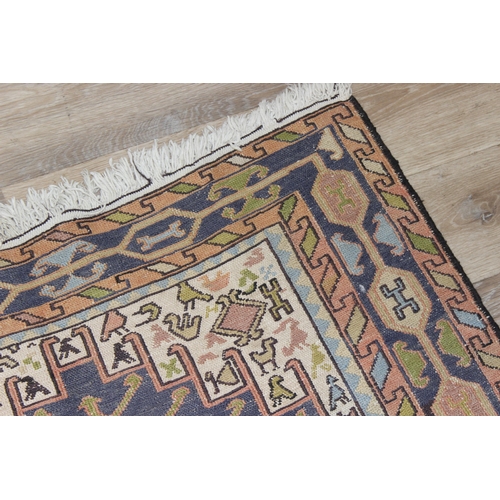 203 - A vintage Persian rug of cream and blue ground decorated with animal motifs and geometric designs, a... 