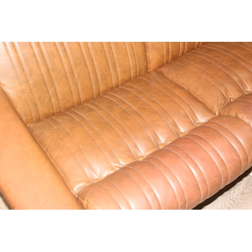 57 - In the manner of Karl Wittmann, a retro brown leather effect sofa with chrome legs, seemingly unmark... 