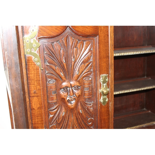 45 - A vintage oak court cupboard with profusely carved detail and brass fittings, approx 111cm wide x 57... 