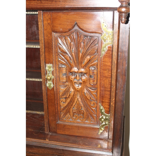 45 - A vintage oak court cupboard with profusely carved detail and brass fittings, approx 111cm wide x 57... 