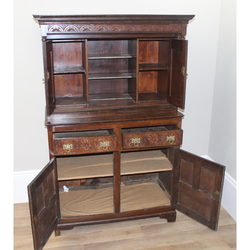 45 - A vintage oak court cupboard with profusely carved detail and brass fittings, approx 111cm wide x 57... 