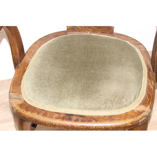 100 - An early 20th century oak desk chair with green fabric seat, approx 84cm tall