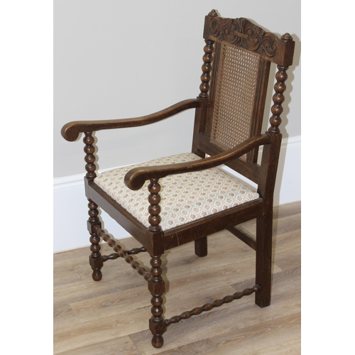 26 - A Carolean style oak armchair with bobbin turned supports and bergere back, approx 91cm tall