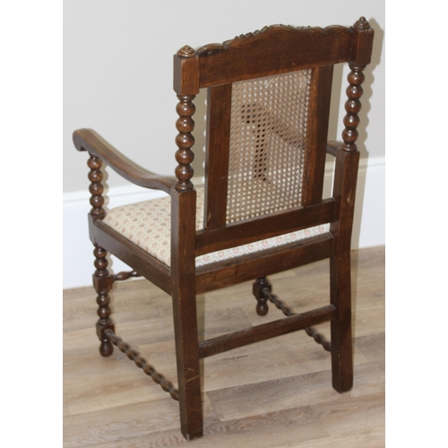 26 - A Carolean style oak armchair with bobbin turned supports and bergere back, approx 91cm tall