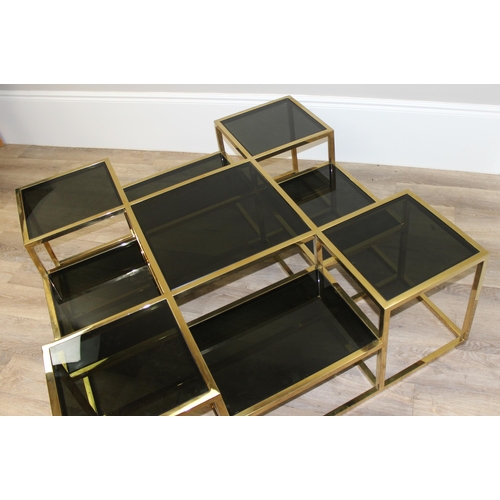 63 - In the manner of Jacob & Jacob, a retro style gold painted and smoked glass coffee table of uneven f... 