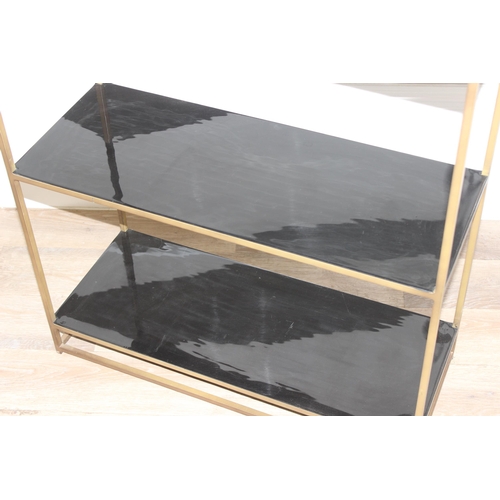 62 - A retro brass framed and black glass shelving unit or bookcase, approx 75cm wide x 30cm deep x 161cm... 